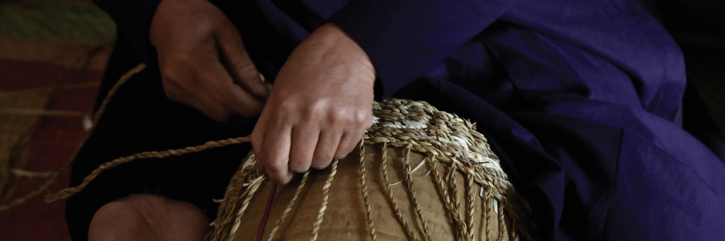 An artisan handweaving natural fibers